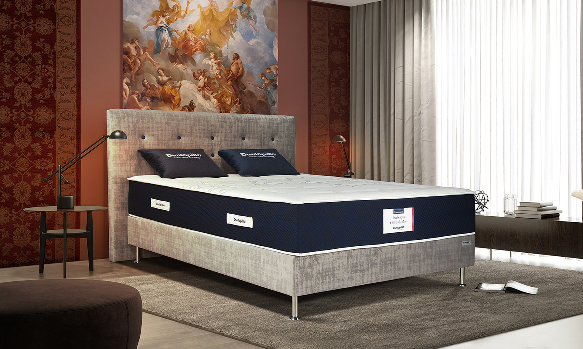 Un matelas avec mousse à mémoire de forme visco aérial et tête de lit en velours gris effet texturé.